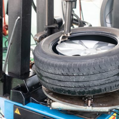 series of worker removing tire from rim with removal machinery 1